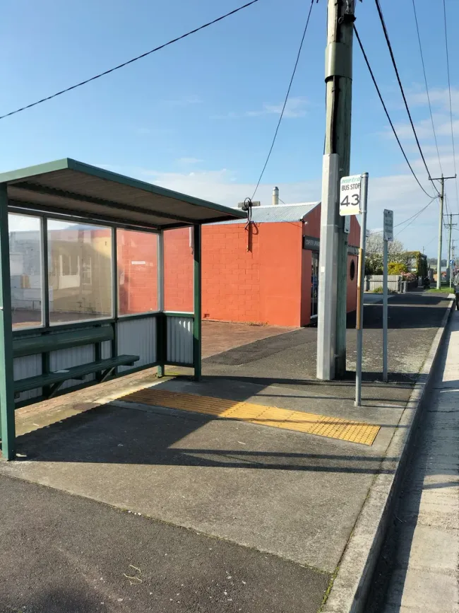A bus shelter in Wynyard with a paved waiting area and tactile paving beside the kerb